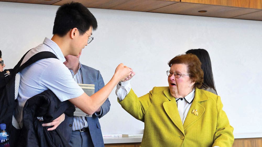 Former Maryland Senator Barbara Mikulki fist bumps with student.