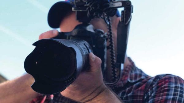 University photographer Will Kirk ’99 holds up his camera ready to shoot.