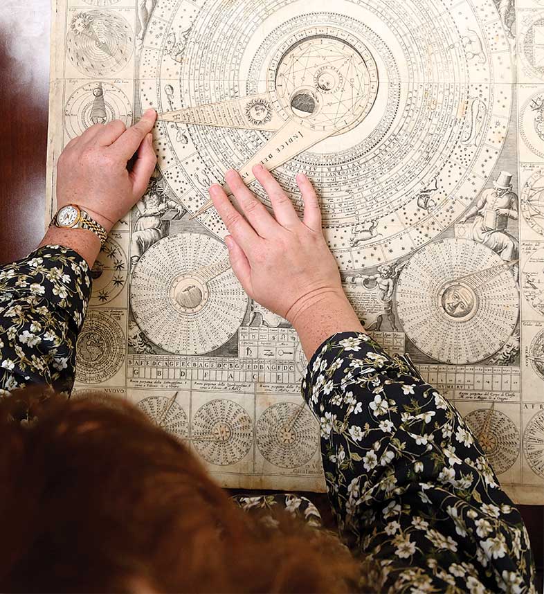 Overhead view of grad student twisting wheels of 17th century "super computer" 