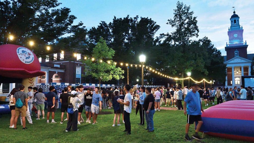 a crowd outside in front of Gilman Hall in early evening during Jay's Carnival