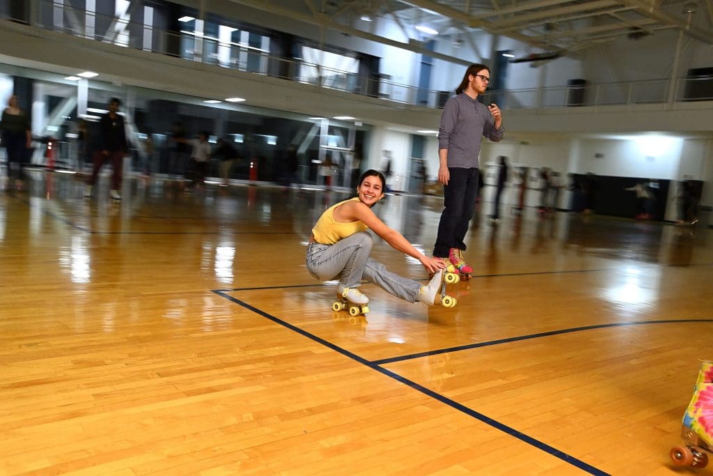 People rollerskating on the Rec Center basketball court