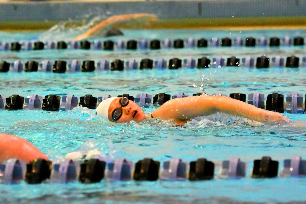 a person half-submerged while swimming laps