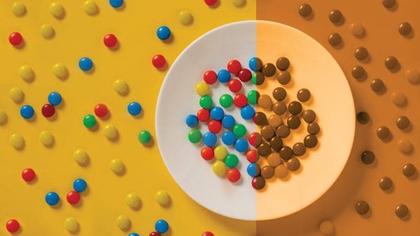 A plate of M&Ms: one half in full color, the other half in monochromatic orange.