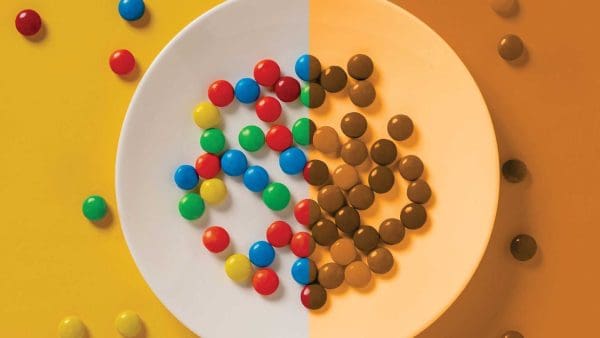 A plate of M&Ms: one half in full color, the other half in monochromatic orange.