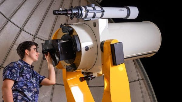 Ezra Sukay looking into telescope.