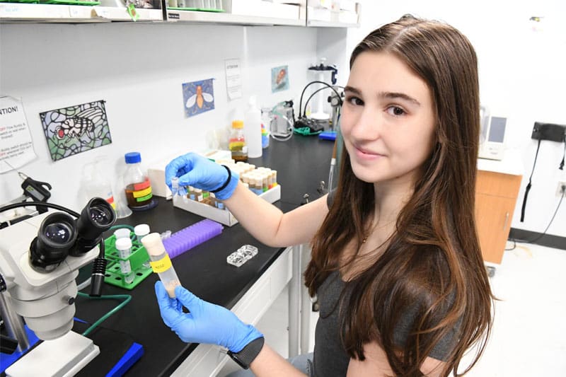 Bella Rowe in lab with fly samples.