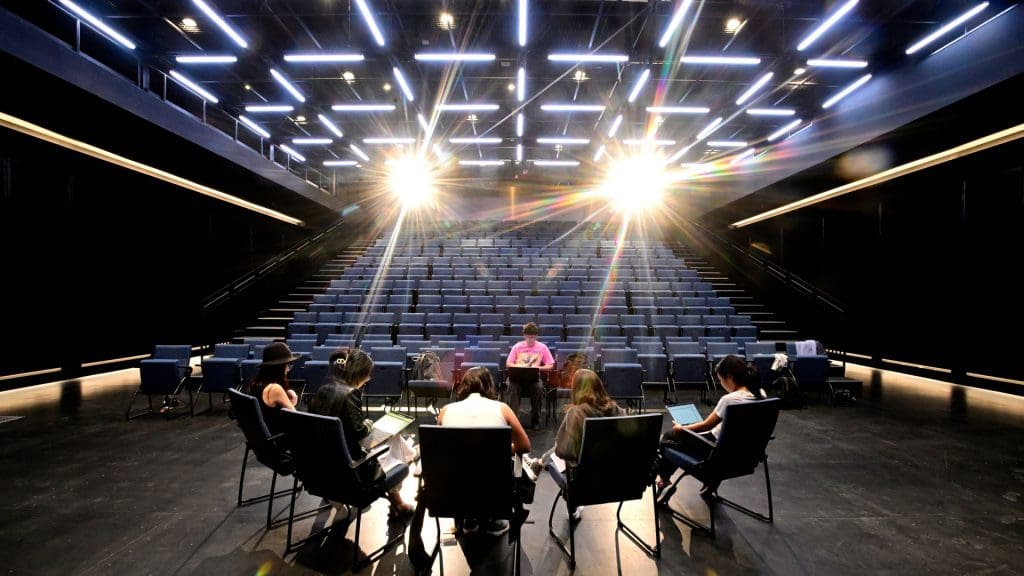 Students gathered in chairs formed in a circle in the black box theater at The Bloomberg Student Center.
