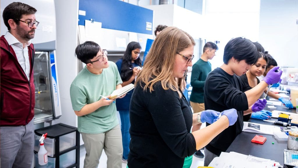 Jason Ludden (far left) and Nichole Broderick (foreground)
in the lab with “Composing the Gene” students.