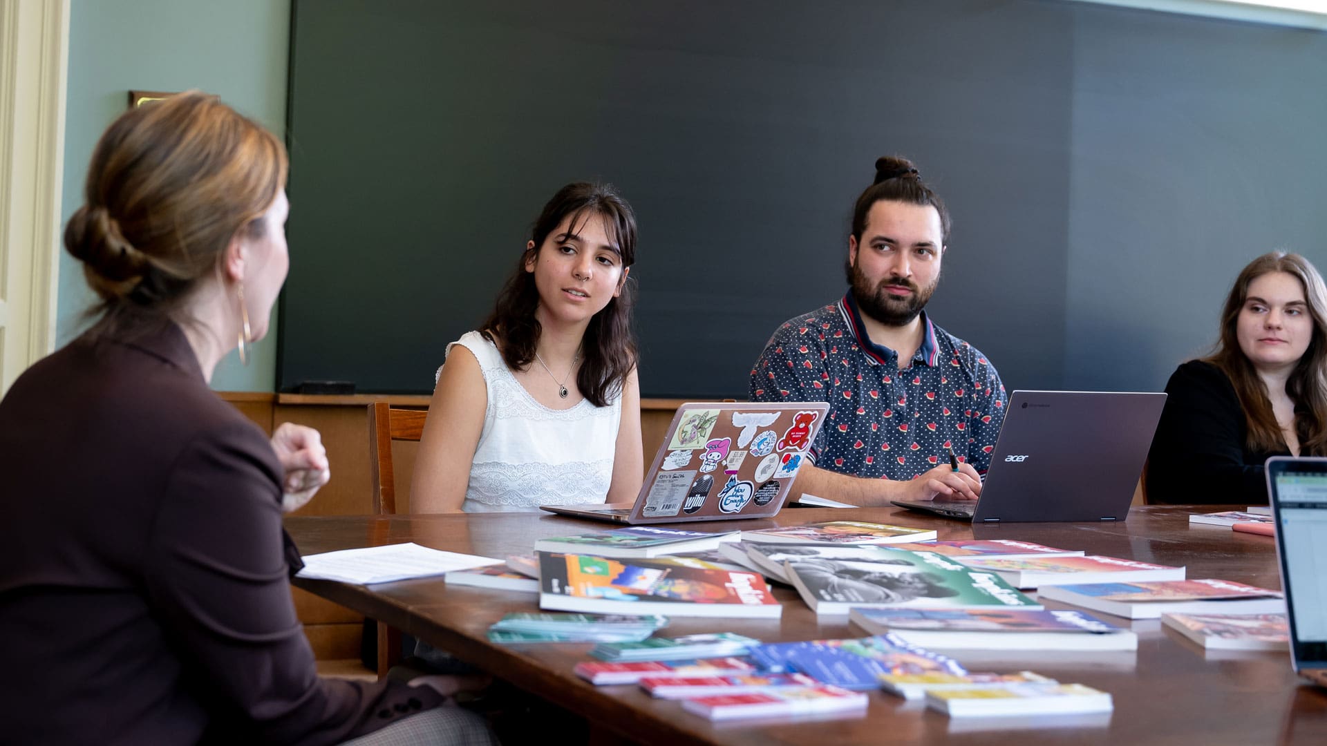 Hopkins Review meeting taking place. Dora Malech in the foreground with students Alejandro Lucero and Adriana Beltrano